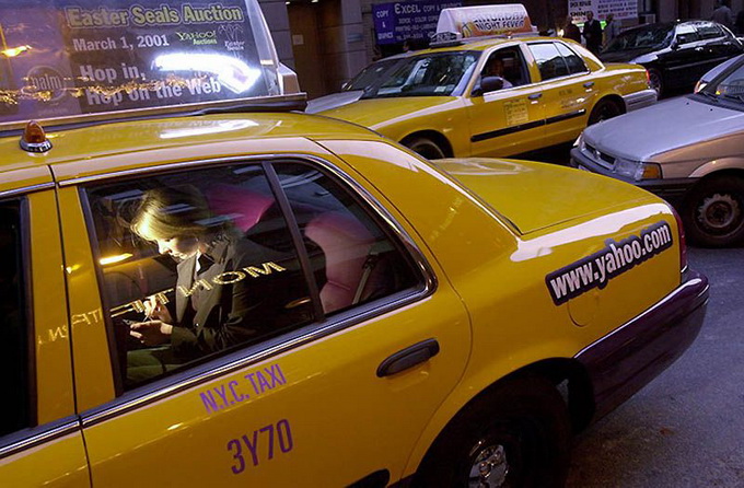 2000. The cab passenger works with the PalmPilot computer in wireless Internet yellow taxi